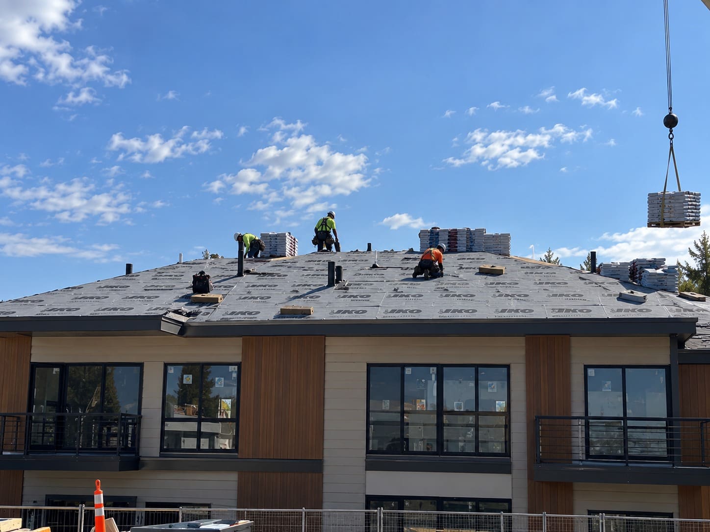 Roofers installing a new roof on a residential building in Gresham