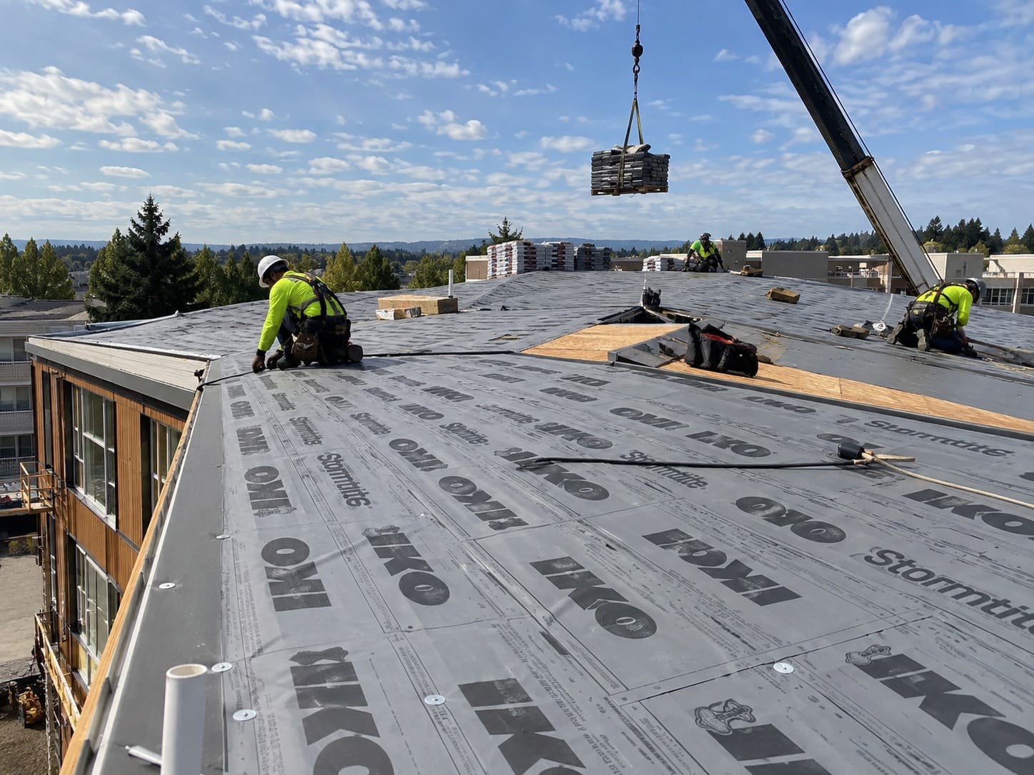 Commercial roofing crew working on a large roof in Gresham, Oregon