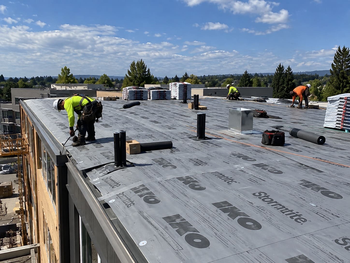 Roofing crew working on a low-slope roof in Gresham, Oregon