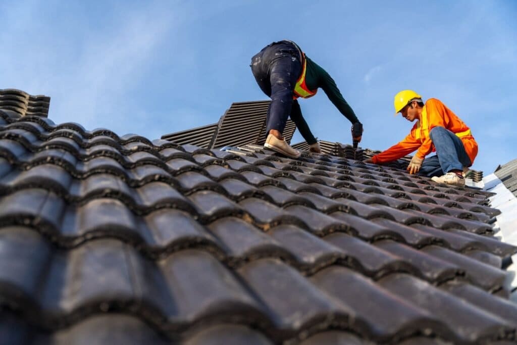 Roofers installing tiles on a tile roof